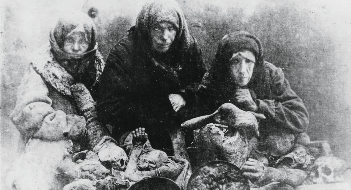 Varias mujeres posan ante la cámara con restos humanos sobre la mesa. Hubo cientos de casos de canibalismo.