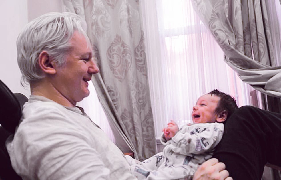 Assange, en una de las pocas fotos con su familia, juega con uno de sus hijos durante su encierro.