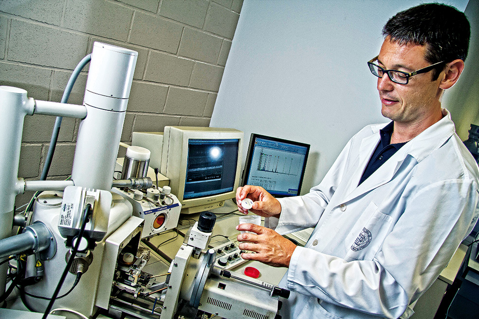 Un técnico del Centro Tecnológico y Naval de Fuente Álamo analiza muestras en busca del original gris claro «como el lomo de una ballena plateada», según una periodista de la época. La labor de decapaje y pintado con pistola (derecha) ha sido ardua, pero las muchas capas de pintura acumuladas le han servido de protección.