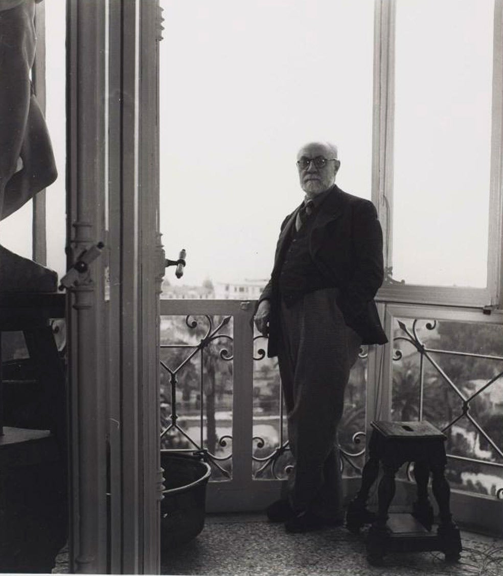 Henri Matisse ante uno de los cuatro balcones, con vistas al Mediterráneo, de su piso en el Régina de Niza. Situado en el boulevard de Cimiez, tiene 157 metros cuadrados. El pintor vivió y creó allí durante diez años.