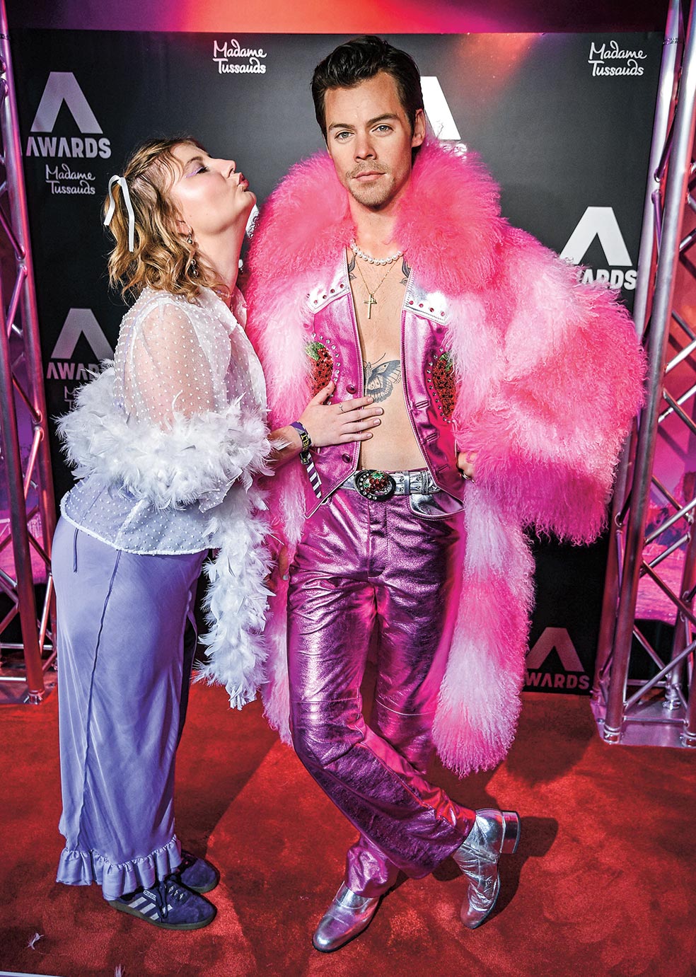 La escultura de cera de Harry Styles en el museo Madame Tussauds en Nueva York lleva el outfit rosa de pantalones metalizados y abrigo de plumas que el cantante lució durante su actuación en Coachella en 2022.