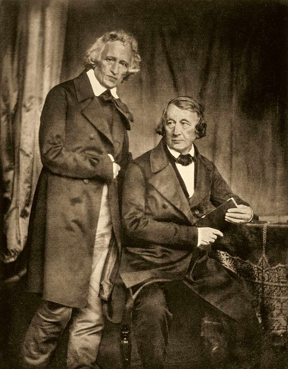 Jacob (de pie) y Wilhelm Grimm, en un daguerrotipo de Hermann Diow. Este retrato fue publicado por primera vez en 1854 para ilustrar su Diccionario alemán. En la imagen anterior, representación fotográfica 'libre' de una de las leyendas orales recuperadas por los hermanos.
