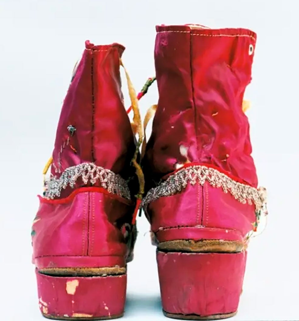 Las botas rosas con tacones de diferentes alturas son una de las señas más distintivas de la pintora mexicana. Kahlo se enfrentó a un interminable desfile por hospitales, salas de operaciones y tratamientos. Llegó a pasar por más de 30 intervenciones a lo largo de su vida. En 1913 enfermó de poliomielitis y su pierna derecha pasó a ser mucho más delgada que la izquierda. De ahí también el contraste de altura entre una pierna y otra.